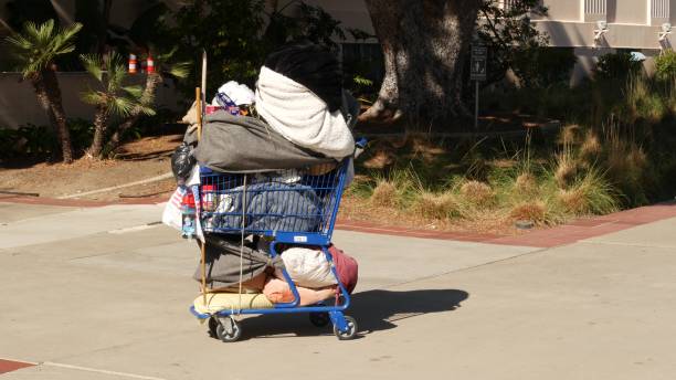 歩道上のホームレスの通りの人々のもの、道端のトラック。ロサンゼルス近郊の街のダウンタウンで物乞いの問題。舗装上の失業乞食トロリーカート - san diego trolley ストックフォトと画像