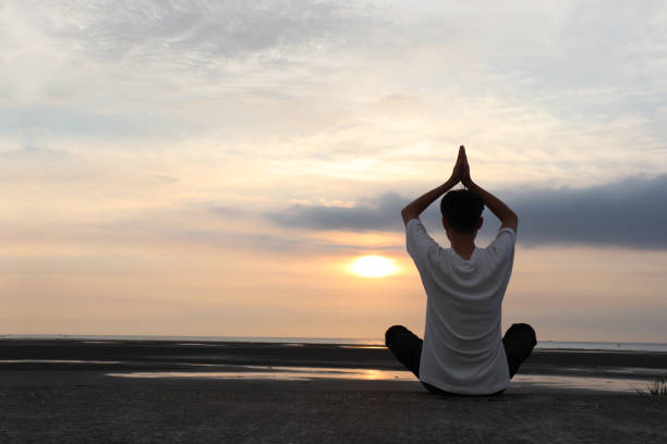 istock Asian man doing yoga on the beach. 1265546956
