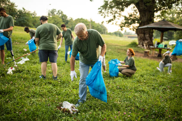 istock Environmental volunteers collecting garbage in garbage bag while cleaning public park 1265548579
