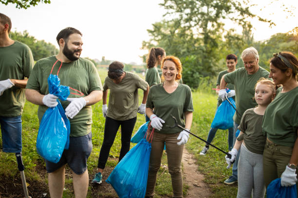 istock Multi-ethnic group of volunteers working together as a team while cleaning public park 1265548606