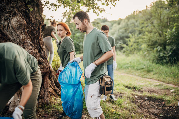 istock Two young people collecting garbage from the public park 1265548639