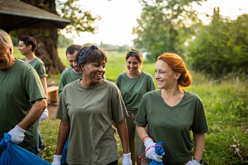 Happy volunteers bonding after environmental cleanup at public park