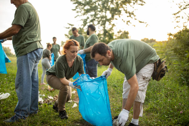 istock Volunteers picking up garbage together while cleaning public park 1265548854
