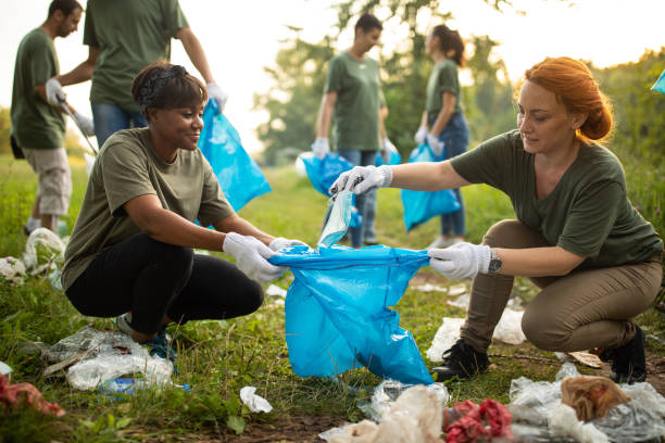 istock Multi-ethnic group of volunteers working together as a team while cleaning public park 1265549098