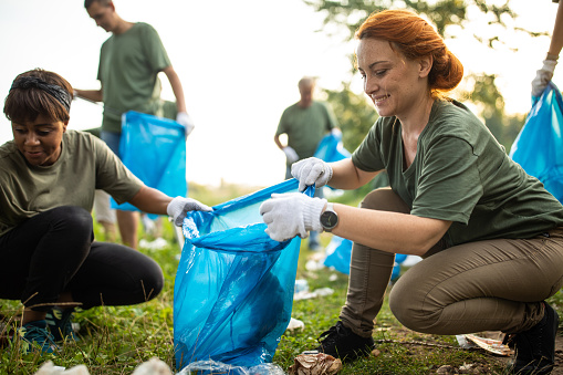 Multi-ethnic volunteers cleaning environment together at public park