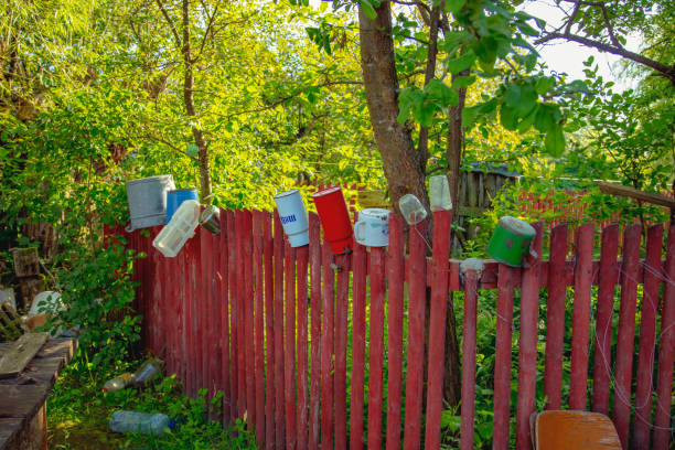 watering can is hanging on the fence