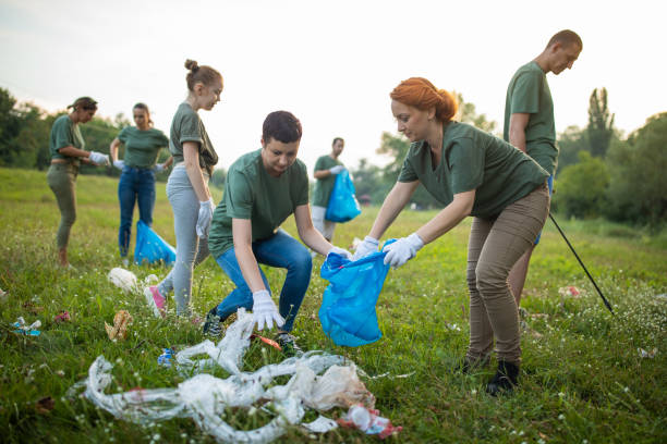 istock Volunteers picking up garbage together while cleaning public park 1265549919
