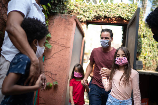 istock Welcoming friends at home during pandemic using surgical mask 1265553361