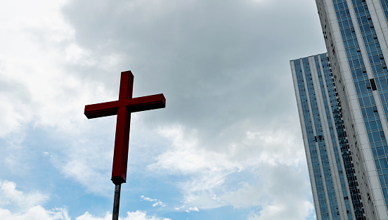 The religious cross next to the city building.