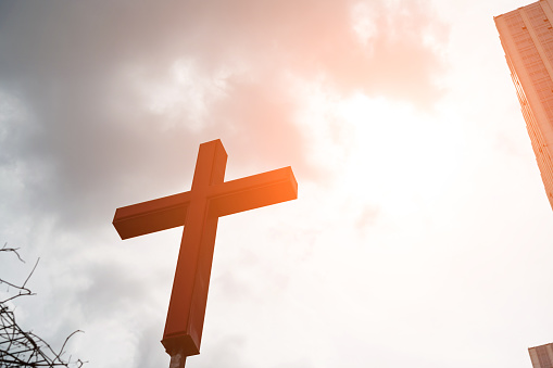 The religious cross next to the city building.