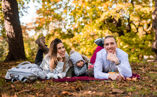 Baby boy whit his parents outdoor.