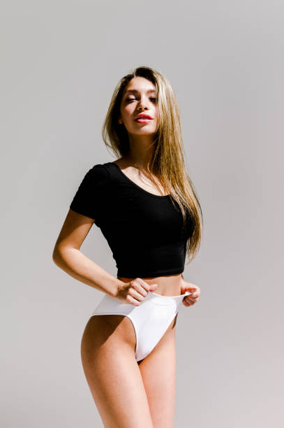Gorgeous Blonde Young Woman With Perfect Body Wearing Black Crop Top And  White Panties On Gray Background Stock Photo - Download Image Now - iStock