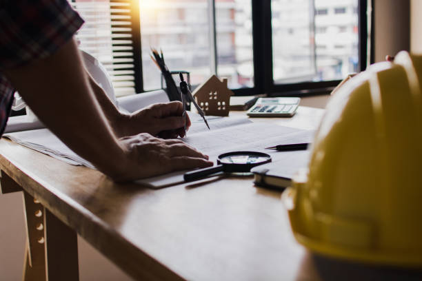istock engineer holding pencil and writing on blue print, check and inspector concept 1265565601