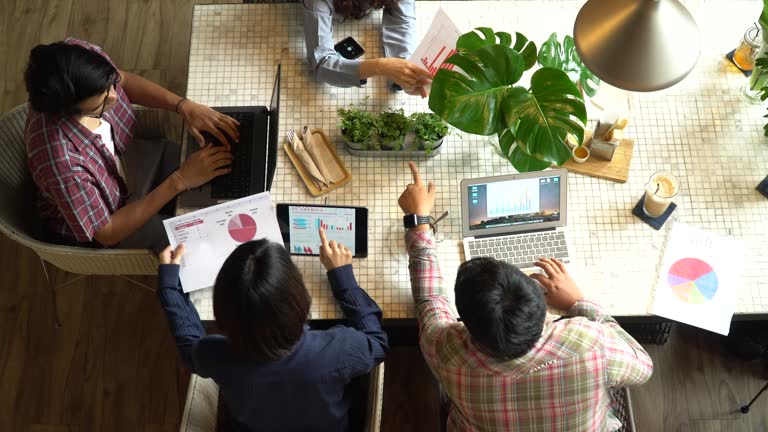 Group of young people on the meeting in modern loft  office desk top view