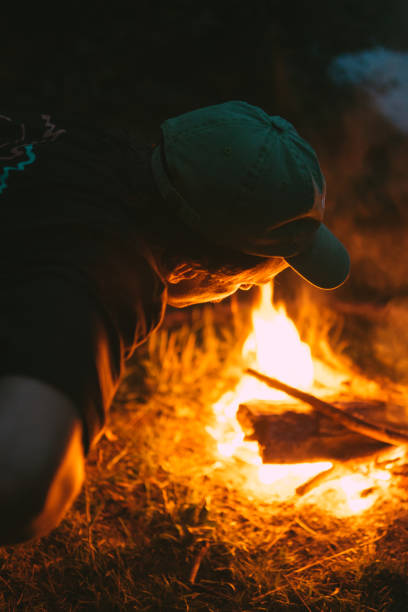 istock Friends burning bonfire in the forest camp 1265568161