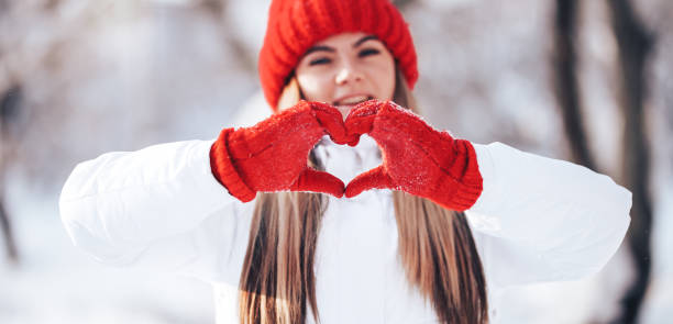 istock Woman making heart symbol with snowy hands 1265568224