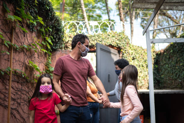 istock Welcoming friends at home during pandemic using surgical mask 1265568539