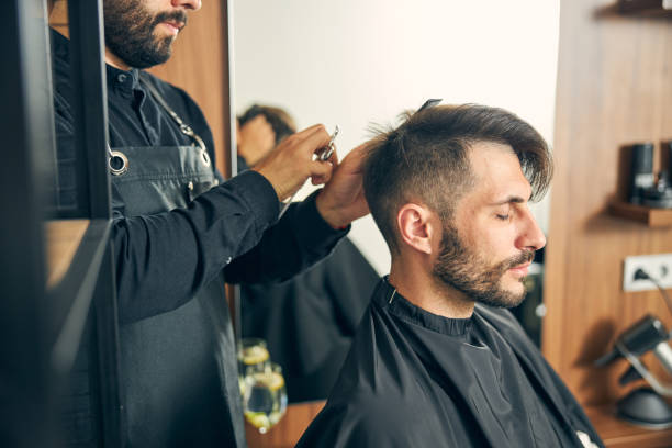 istock Concentrated master cutting hair of his client 1265569719