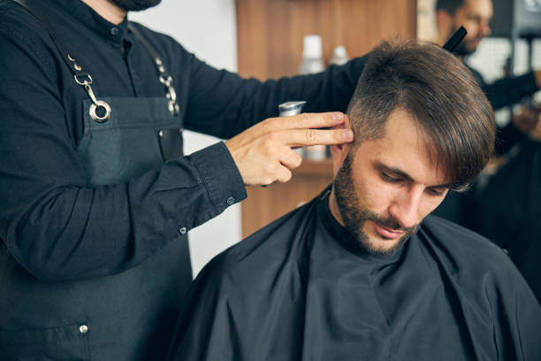 istock Close up of barber doing modern hairstyle 1265572442
