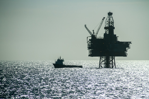 Silueta de un buque de suministro offshore junto con la plataforma petrolífera Ringhorn en el Mar del Norte photo