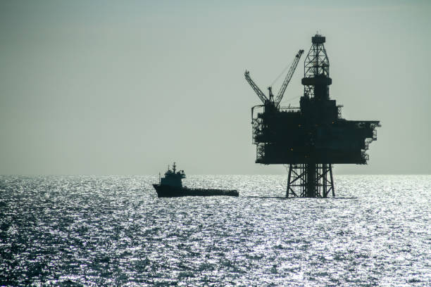 Silhouette of an Offshore Supply Vessel alongside oil platform Ringhorn in the North Sea NORTH SEA, NORWAY - 2011 APRIL 23. Silhouette of an Offshore Supply Vessel alongside oil platform Ringhorn in the North Sea north sea oil and gas stock pictures, royalty-free photos & images