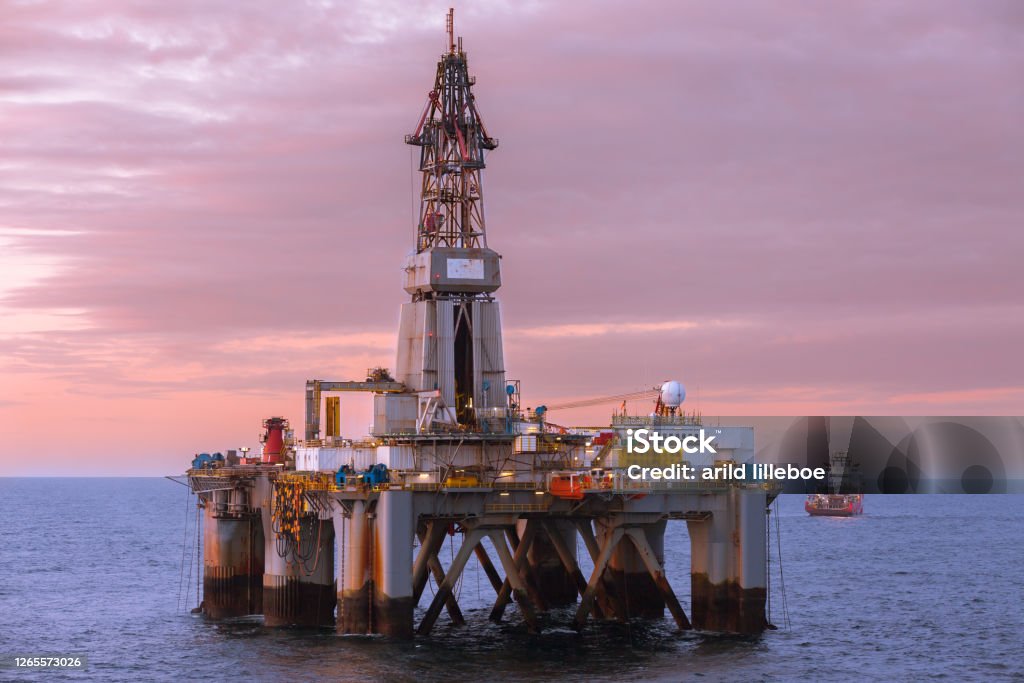 Beautiful sunset at offshore at oil rig Transocean Prospect and offshore vessel KL Sandefjord in North Sea. NORTH SEA, NORWAY - 2015 MAY. Beautiful sunset at offshore at oil rig Transocean Prospect and offshore vessel KL Sandefjord in North Sea. Offshore Platform Stock Photo