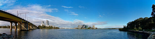 istock Beautiful panoramic view of a railway bridge over a river on a sunny day with deep blue sky and fluffy clouds 1265573034