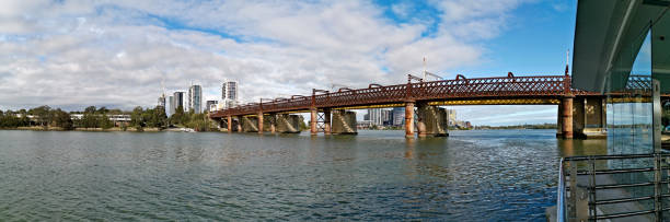 istock Beautiful panoramic view of a railway bridge over a river on a sunny day with deep blue sky and fluffy clouds 1265576318