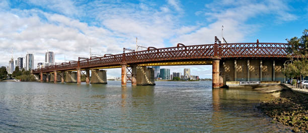 istock Beautiful panoramic view of a railway bridge over a river on a sunny day with deep blue sky and fluffy clouds 1265577671