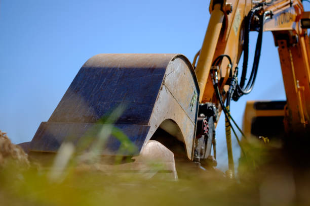 Excavator bucket rests against a stone