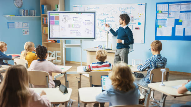 grundskolan science teacher använder interaktiv digital whiteboard för att visa classroom full av barn hur software programming fungerar för robotics. science class, nyfiken kids lyssna uppmärksamt - study school bildbanksfoton och bilder