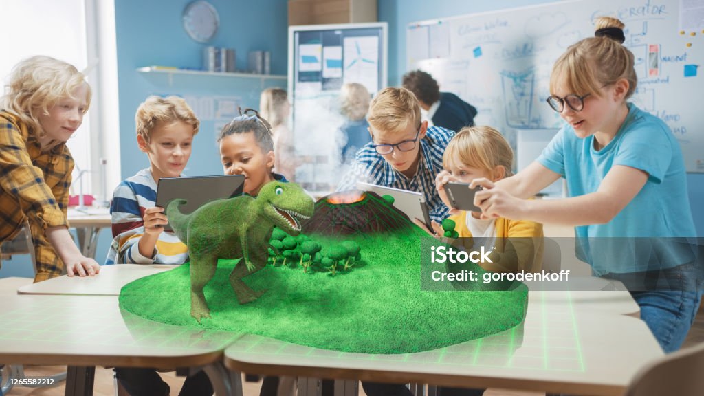 Group Of School Children Use Digital Tablet Computers With Augmented  Reality App Looking At Educational 3d Animation Dinosaur Walking On Island  With Active Volcano Vfx Special Effects Render Stock Photo - Download