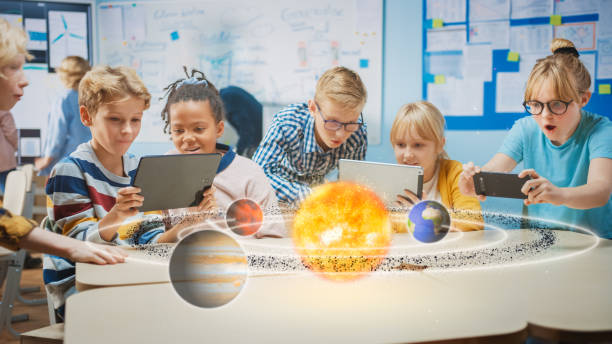 과학 클래스의 학교 어린이 그룹은 증강 현실 소프트웨어와 디지털 태블릿 컴퓨터를 사용, 태양계의 교육 3d 애니메이션을보고. vfx, 특수 효과 렌더링 - applied science 뉴스 사진 이미지