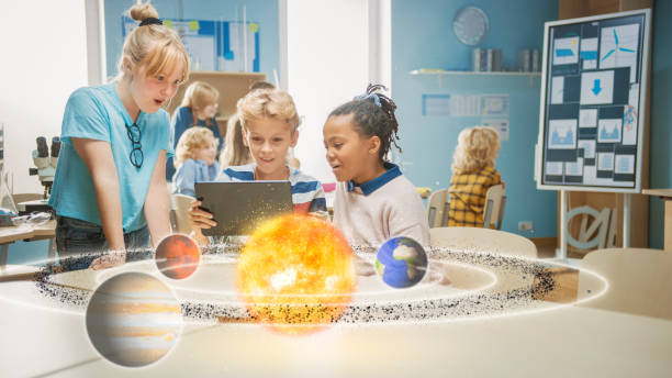 три �разнообразных школьников в классе науки использовать цифровой планшетный компьютер с дополненной реальности программного обеспечени - learning child education globe стоковые фото и изображения