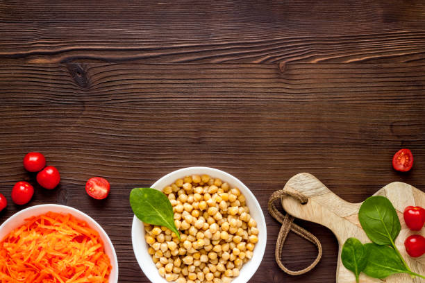Vegetarian bowl with chickpeas and vegetables - wooden table top view copy space