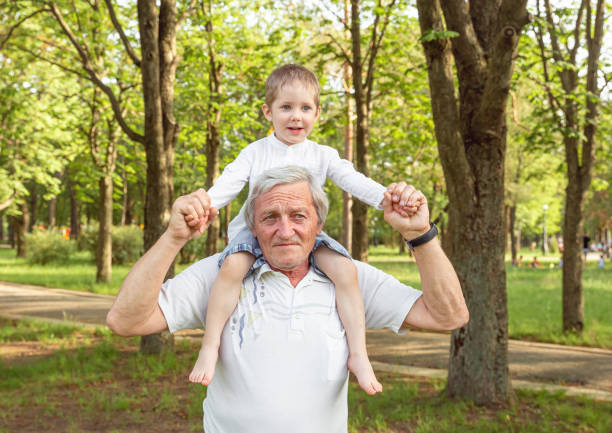 istock Senior man with a toddler boy spending time in nature in summer 1265584432