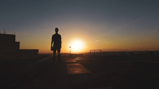 istock Man photographer silhouette at sunset 1265584907