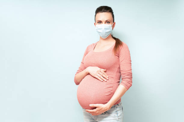 Pregnant Woman in Medical Face Mask against flu and viruses. Healthcare concept, copy space. Pregnancy And Infection concept. High resolution stock photo