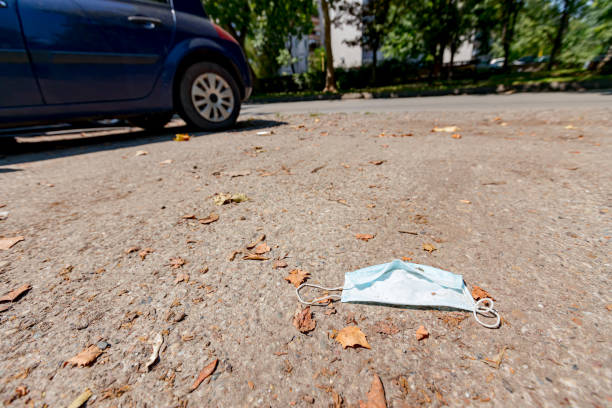 istock Disposable dirty face mask on ground, waste environmental pollution 1265587759