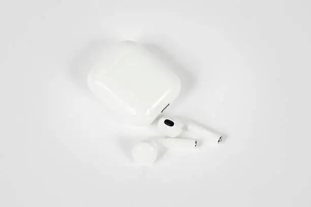 Photo of In-ear headphones with charging case on white background