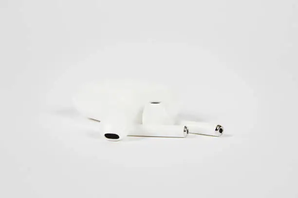 Photo of In-ear headphones with charging case on white background