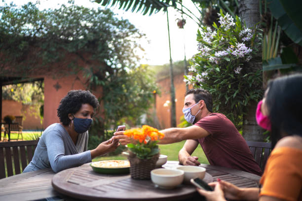 istock Friends reunited in the backyard, talking and using smartphone 1265600827