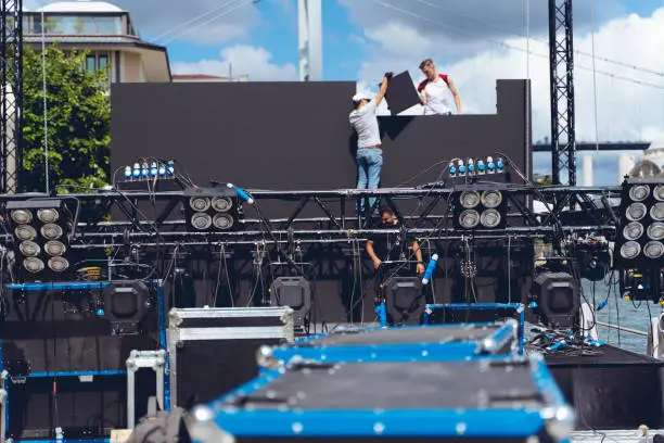 Photo of lighting and Led panel technician installing professional lighting equipment for concert stage , installation with led lights, led panel and projectors