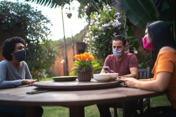 istock Friends reunited in the backyard, talking and using smartphone 1265602795