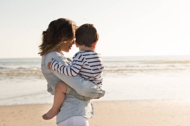 istock Mother at the beach with her baby 1265602905