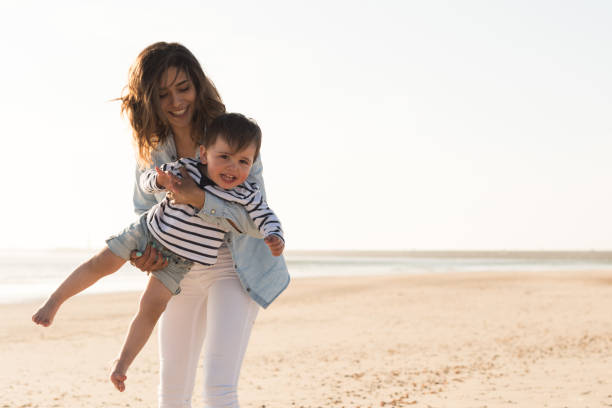 istock Mother at the beach with toddler 1265602910