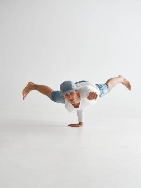 istock Young breakdancer stands on one arm dancing hip-hop isolated on white background. Break dance school poster 1265604680