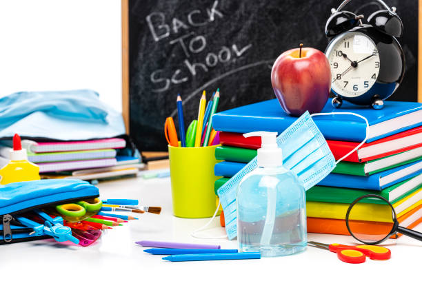 istock Back to school: school supplies, protective face mask and hand sanitizer on white background. 1265607701