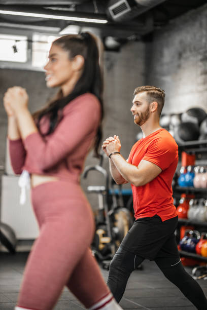 istock Young people doing lunges together during their workout in a gym 1265608401