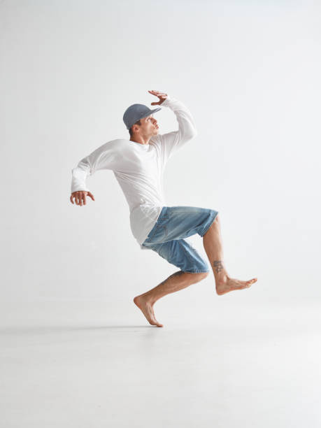 istock Cool young man breakdancer dancing expressive dance in white studio. Dance school poster. Breakdance lessons 1265609189